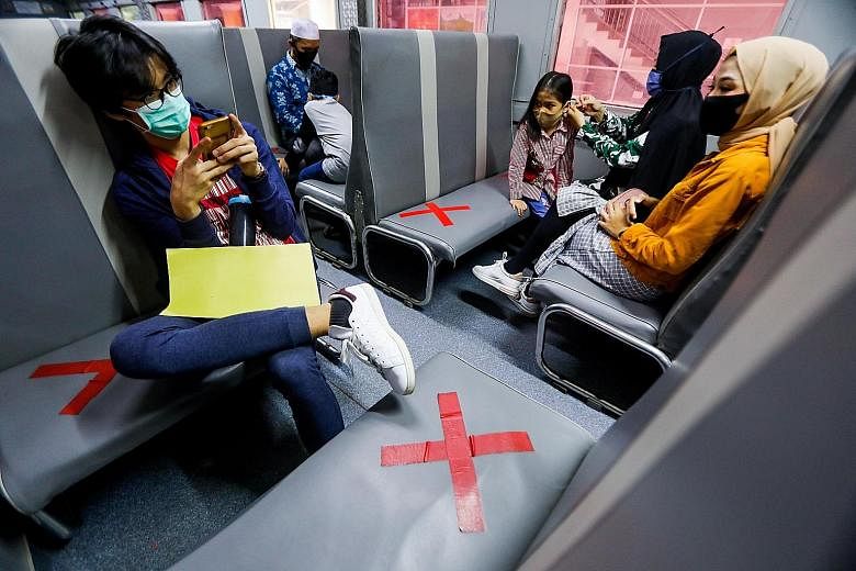 People in Medan, wearing face masks, kept a safe distance from one another on a train where no-seating signs have been marked out. PHOTO: EPA-EFE