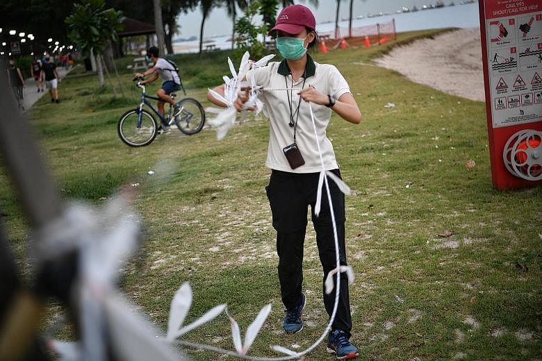 A National Parks Board employee removing a barrier at East Coast Park yesterday in preparation for phase two of the economy reopening. Sports facilities are reopening today, as well as beaches and playgrounds. ST PHOTO: ARIFFIN JAMAR