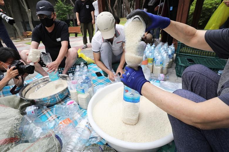 Defector activists putting rice into plastic bottles at a park in Seoul yesterday. They plan to let the bottles float to North Korea via waters off the western island of Ganghwa bordering the North, despite the South Korean government's crackdown on 