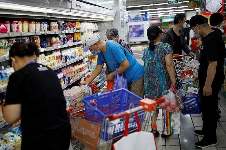 Customers inside a Beijing supermarket yesterday. Shops, restaurants and hair salons in many neighbourhoods in the city are still operating, despite the latest coronavirus outbreak linked to the Xinfadi market.