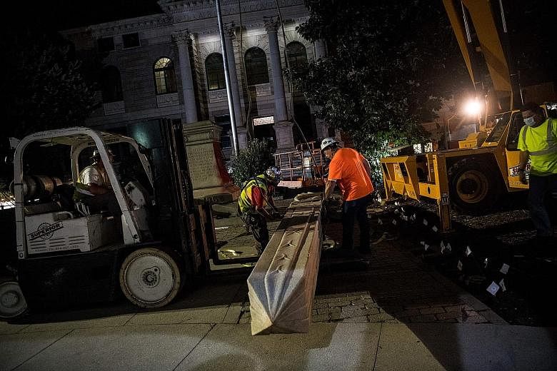 Members and supporters of Beacon Hill Black Alliance for Human Rights celebrating as workers removed the Confederate monument in Decatur, on the eve of Juneteenth. PHOTO: AGENCE FRANCE-PRESSE Workers removing a Confederate monument in Decatur, north-