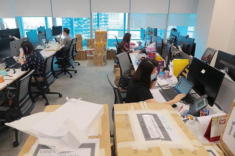 Staff observing safe distancing while at work at HSBC Singapore's new head office in Marina Bay Financial Centre Tower 2 yesterday. HSBC is the anchor tenant, occupying the top seven floors of the 50-storey building.