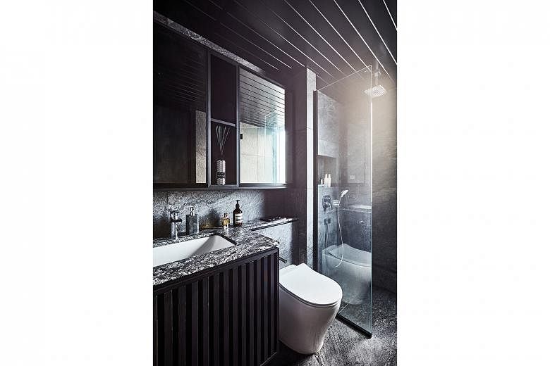 The bathroom’s sleek set-up adheres to the dark palette.