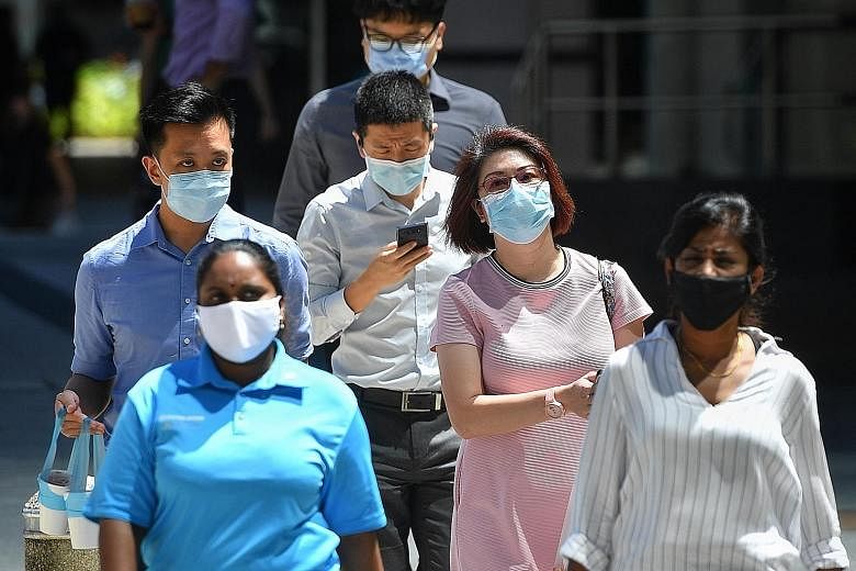 Residents at S11 Dormitory in April. Observers agree that the high numbers of infection among workers in dormitories could be an area of criticism on how the Covid-19 outbreak was handled by the Government. People waiting their turn to submit their a