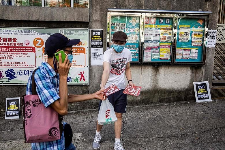 A volunteer handing out pamphlets in Hong Kong yesterday, outside a venue where some pro-democracy unions were holding a vote to ask members if they would participate in a citywide strike and if they supported China's plans to impose a new national s