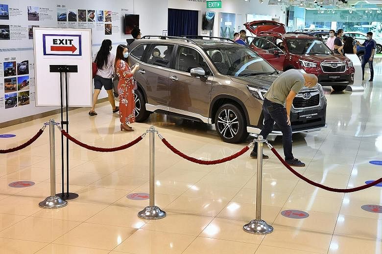 A Subaru car showroom and the sales gallery for condo development Kopar At Newton yesterday, on the first weekend of reopening after the circuit breaker period. It was not quite business as usual, however, as patrons had to scan in using SafeEntry an