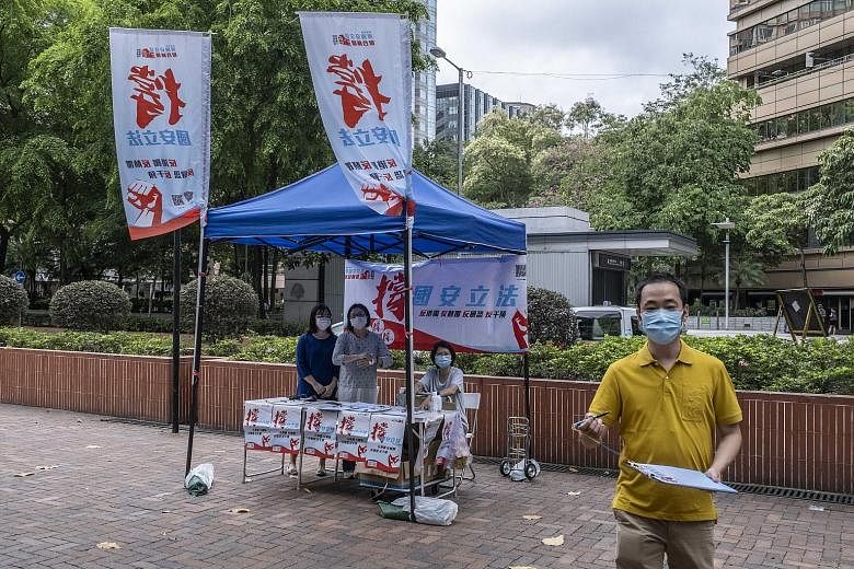 People collecting signatures for a petition supporting China's new national security law in Hong Kong on May 29. Beijing and its supporters insist that the law is meant to "protect" the one country, two systems process.