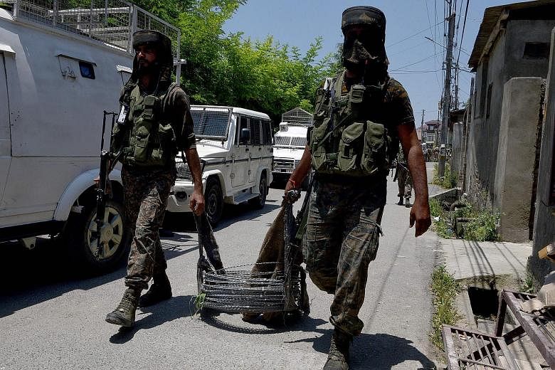Soldiers at the site of a firefight in the Zoonimar area of Srinagar on Sunday. India has stepped up counter-insurgency efforts in the disputed territory since March. PHOTO: AGENCE FRANCE-PRESSE