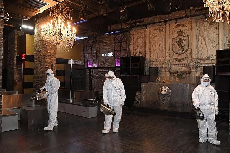Quarantine workers disinfecting a night club in Itaewon in Seoul after crowds gathering over a holiday weekend in May sparked a fresh wave of coronavirus infections in the South Korean capital. PHOTO: REUTERS