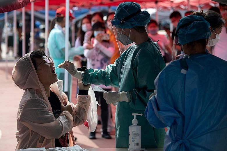 A health worker in a protective suit doing a swab test during mass testing for Covid-19 in Beijing yesterday. Officials said they are ramping up screening as the number of infections continues to rise.