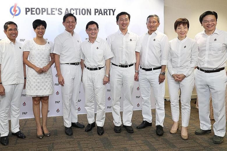 National Development Minister Lawrence Wong (second from left) and his Marsiling-Yew Tee GRC team - (from left) Mr Ong Teng Koon, Mr Zaqy Mohamad and Mr Alex Yam - are launching a series of live chats with residents on Facebook today, amid limits on 