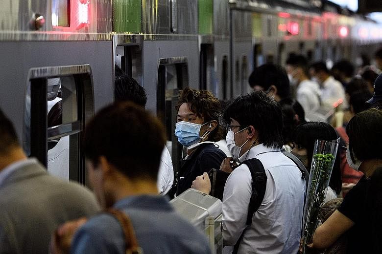 People boarding a train at Shinagawa station in Tokyo during the evening rush hour yesterday. The daily number of new Covid-19 cases in the Japanese capital climbed to 55 yesterday. Amid the spike in cases, traffic at major stations in the city has b