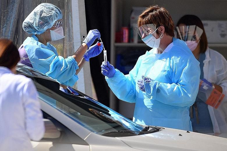 Medical workers collecting samples at a drive-through testing facility in San Francisco in March. The United States is among countries that have administered saliva tests to detect Covid-19. PHOTO: AGENCE FRANCE-PRESSE