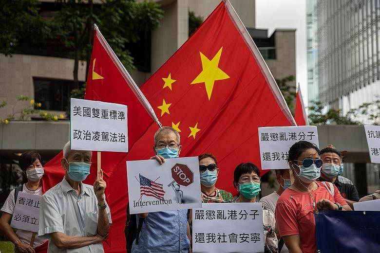Pro-China activists with banners and Chinese national flags during a march to the US Consulate-General in Hong Kong yesterday, protesting against the US Senate-backed legislation that would allow sanctions in the United States to be imposed on indivi