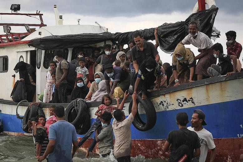 Acehnese locals helping Rohingya refugees to disembark from a boat on their arrival at Lancok beach, North Aceh, Indonesia, on Thursday. Many Rohingya people were rescued at sea by Indonesian fishermen and officials while drifting on a broken boat in