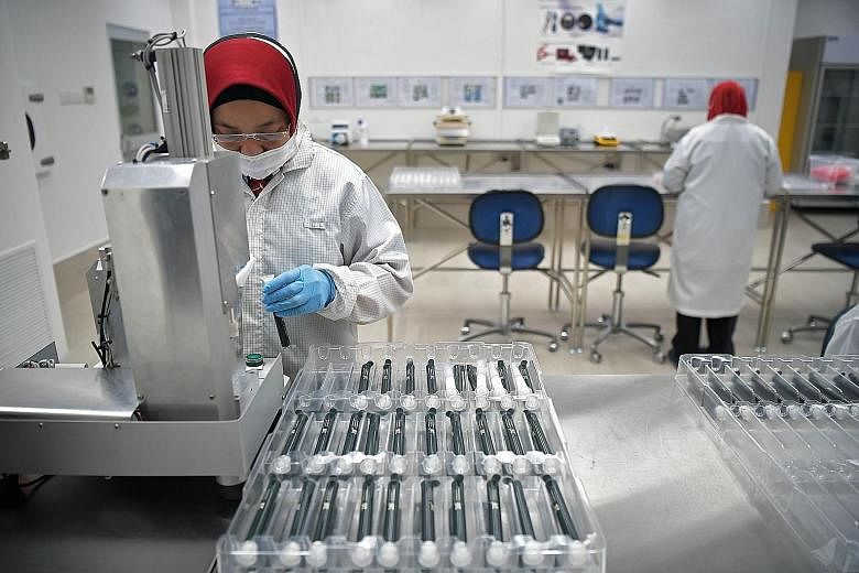 Staff at work in the manufacturing department of Racer Technology, which designs and makes medical devices and laboratory equipment. Growth in Singapore's medical technology segment fell 20.1 per cent last month, partly due to circuit breaker measures. 