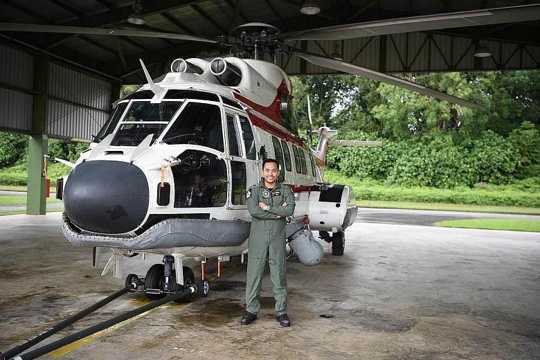 Captain Muhammad Azlan Latiff with the Super Puma helicopter he flies. His promotion to major takes effect on July 1. PHOTO: MINISTRY OF DEFENCE