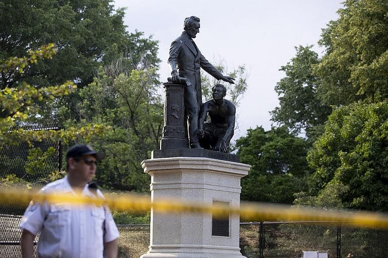 The Emancipation Memorial in Washington being guarded by a police officer last week. Following last month's death of unarmed black man George Floyd in police custody, protests of outrage have led to the vandalism of monuments and memorials in many pa