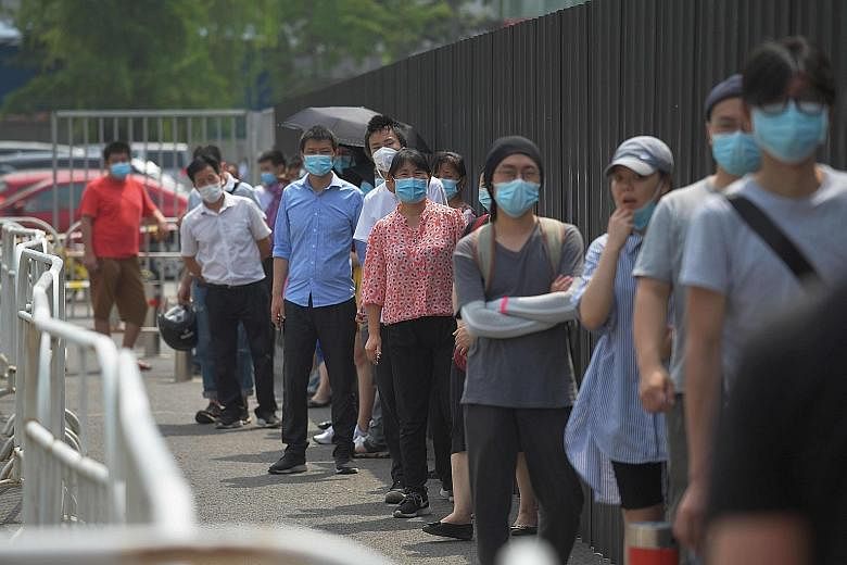 People waiting to undergo Covid-19 swab tests at a testing station in Beijing yesterday. Local officials have urged people not to leave the city, closed schools again and locked down dozens of residential compounds to stamp out the virus.