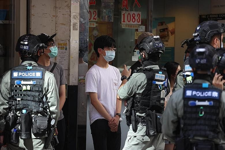 A pro-democracy protester being detained by police during yesterday's silent march in Kowloon district, Hong Kong.