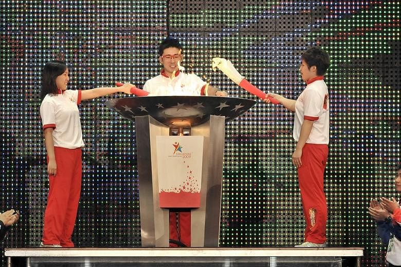 (From left) Shooter Jasmine Ser, bowler Remy Ong and swimmer Tao Li lighting the cauldron at the opening of the Asian Youth Games on June 29, 2009.