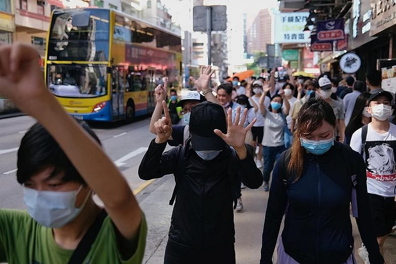 Pro-democracy protesters in Hong Kong raising their hands and signalling their "five demands, not one less" message to the authorities during a march on Sunday against the looming national security legislation. The controversial law, reported to carr
