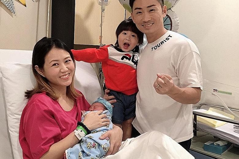 Local singers Tay Kewei and Alfred Sim with their elder son Momo and their new baby.