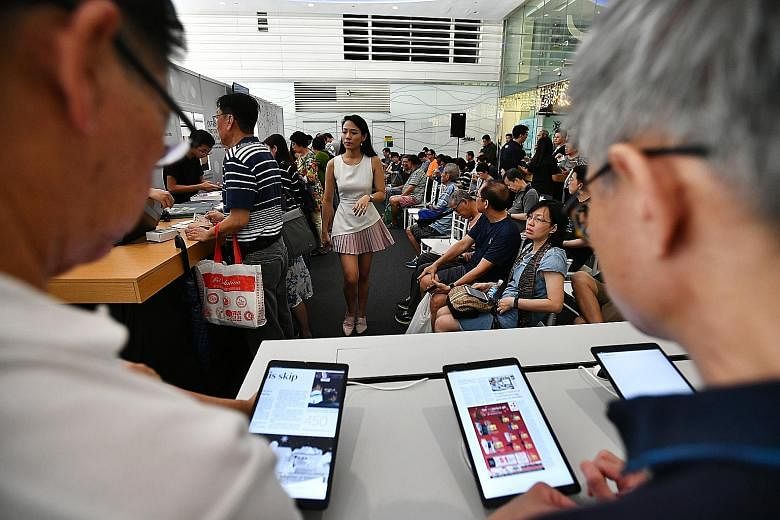 Subscribers of The Straits Times waiting to collect the news tablet last December. Readers have given the news tablet, which offers the convenience of reading traditional print papers in a digital format, positive reviews. The ST Tab app is pre-insta