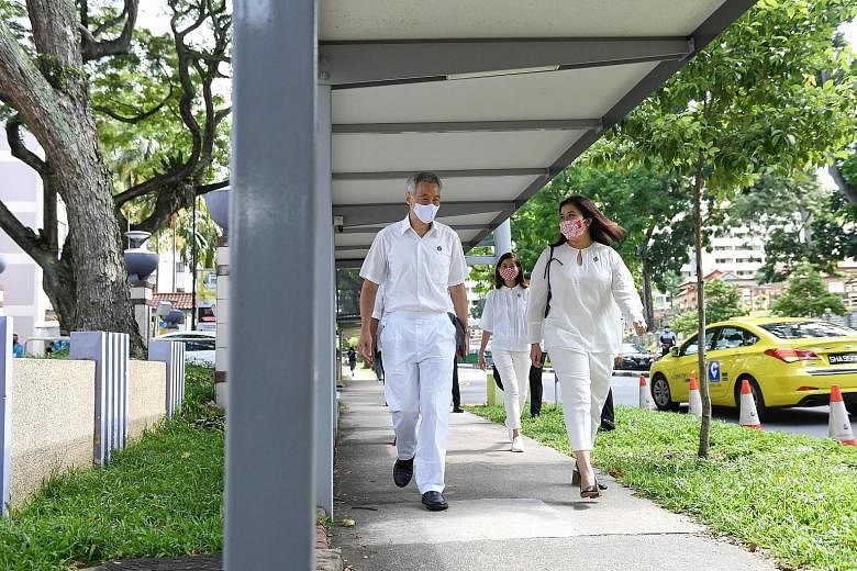 Prime Minister Lee Hsien Loong and fellow Ang Mo Kio GRC team member Nadia Ahmad Samdin on their way to Deyi Secondary School nomination centre yesterday. ST PHOTO: SHINTARO TAY