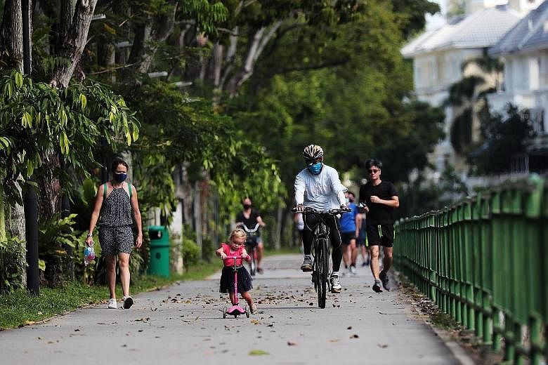 A cyclist breezing through the path of the Ulu Pandan Park Connector while sharing it with a girl on her kick scooter in May, while Singapore was in the circuit breaker to halt the transmission of the coronavirus.