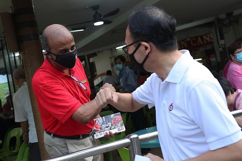 Singapore Democratic Party chairman Paul Tambyah and his rival Bukit Panjang SMC candidate Liang Eng Hwa of the People's Action Party greeting each other while meeting residents in Bangkit Road yesterday.