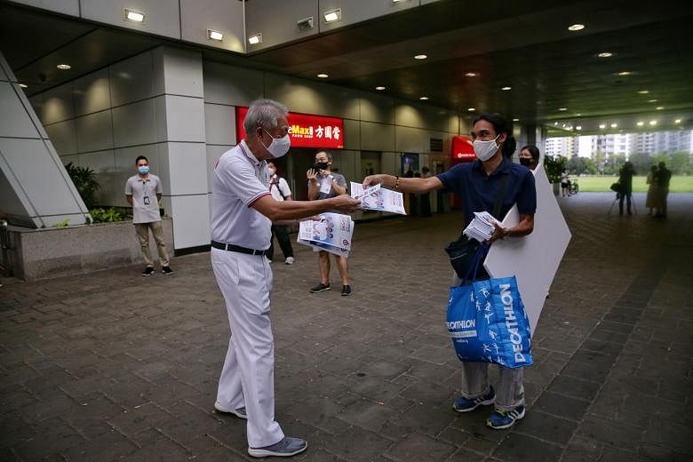 Senior Minister Teo Chee Hean, who is anchoring PAP's Pasir Ris-Punggol GRC team, at Punggol MRT station yesterday exchanging fliers with Mr Prabu Ramachandran, who is on the Peoples Voice's slate contesting the same group representation constituency