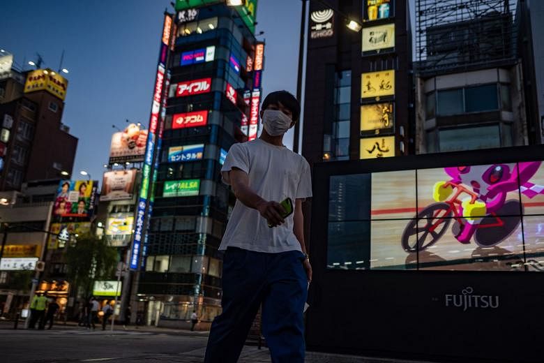 A masked man in Tokyo's Shimbashi district yesterday. The Japanese capital has reported more than 50 cases every day for the past week, prompting Governor Yuriko Koike to urge residents to refrain from going to night-time entertainment places such as