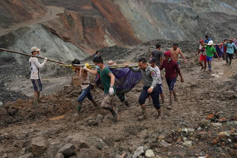 Rescuers pulling out mud-slaked bodies from the jade mine in Hpakant, Myanmar, after the landslide yesterday. The mine workers were scavenging for gemstones on the sharp mountainous terrain, where furrows from earlier excavations had already loosened