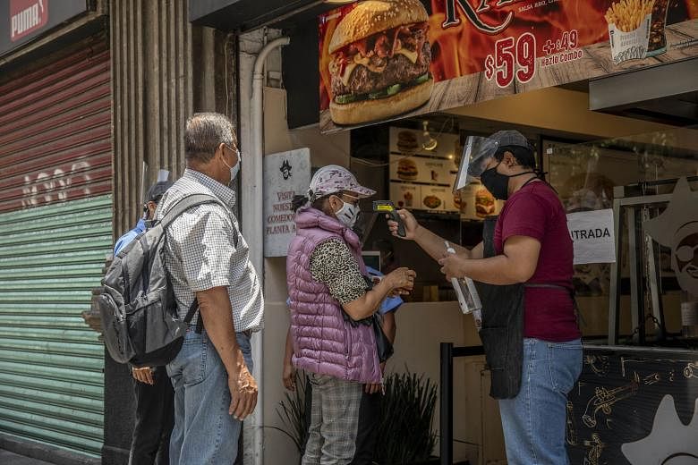 Customers outside a restaurant in Mexico City on Wednesday. The capital of Mexico began reopening businesses this week.