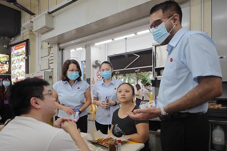 Workers' Party chief Pritam Singh, accompanied by party chairman Sylvia Lim (far left) and Punggol West SMC candidate Tan Chen Chen, chatting with customers at a coffee shop in Punggol Way yesterday.