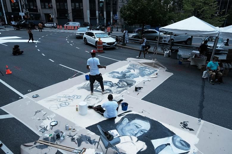 Artists painting a Black Lives Matter mural on a New York City road on Thursday. The #StopHateForProfit movement, aimed at pushing social networks to suppress posts that promote racism, has gained momentum in the wake of Mr George Floyd's death in po