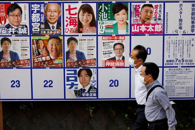 A wall of posters featuring candidates in Tokyo's election tomorrow. Governor Yuriko Koike (top row, in green blazer) is tipped to be re-elected, having won praise for her decisive handling of the Covid-19 outbreak. PHOTO: REUTERS