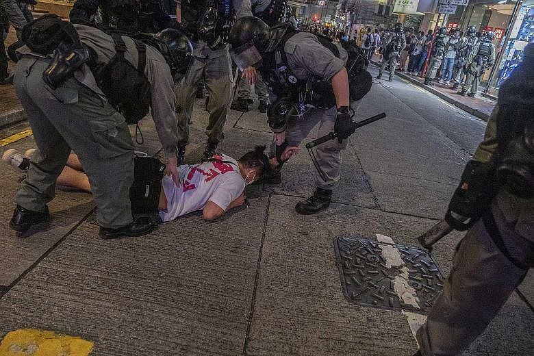 Police arresting a protester at a shopping area in the Causeway Bay area of Hong Kong last Wednesday. Hong Kong's economic environment has suffered greatly from the year-long social unrest, unstable foreign trade and the Covid-19 pandemic.