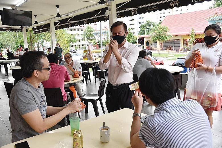 HONG KAH NORTH: Senior Minister of State Amy Khor, who is defending her single seat, posing for a photograph with residents at Block 445A, Bukit Batok West Avenue 8, on Wednesday. HOLLAND-BUKIT TIMAH: (From left) Singapore Democratic Party member Mat