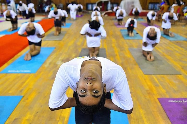 Students doing stretching exercises on International Yoga Day in Agartala, India, last month. PHOTO: AGENCE FRANCE-PRESSE