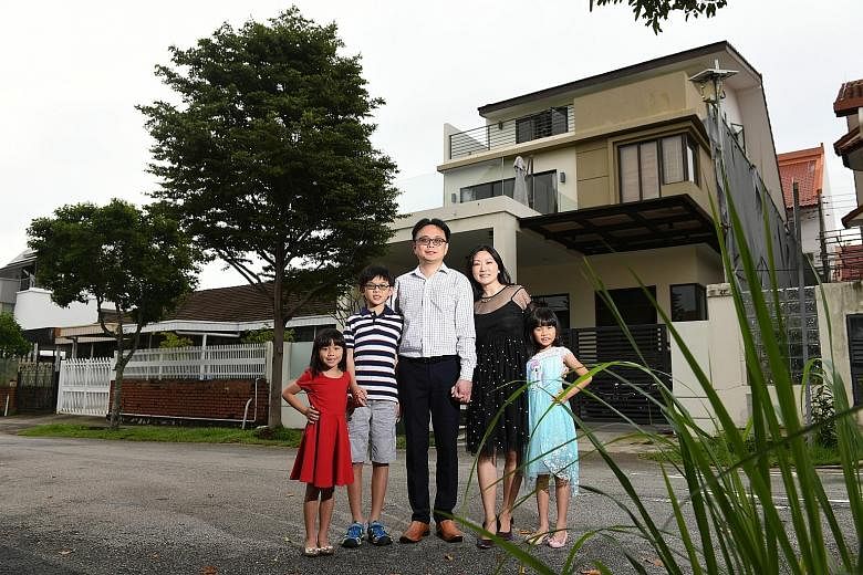 Ms Li and her family with their house in the background. The previous owner had planted a huge tree in front that blocks out the heat and provides shelter.