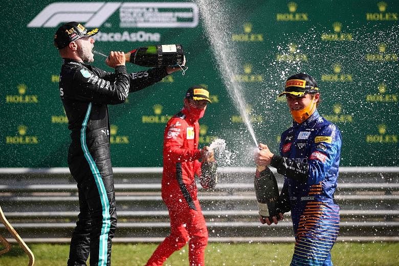 From left: Valtteri Bottas, Charles Leclerc and Lando Norris allowing themselves some liberal celebration with champagne after finishing on the podium in F1’s delayed season-opener in Austria.