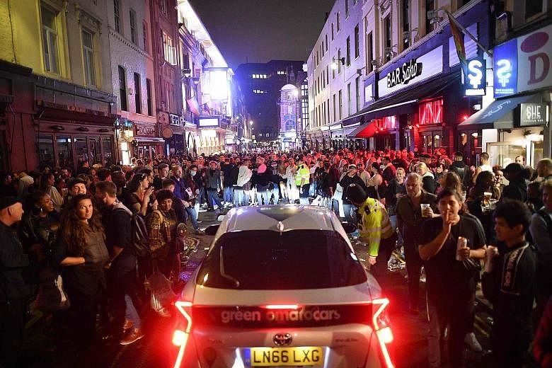 Revellers gathering in London's Soho area on Saturday, after pubs in England reopened that day for the first time since late March. Experts in Singapore say safe distancing and hygiene measures already in place here are generally sufficient to keep t