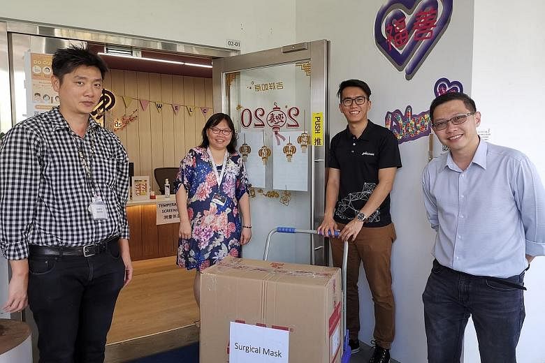 Ms Ong Siew Chin, chief executive of Blossom Seeds - a charity that helps seniors - receiving a donation of surgical masks from tech company Micron, delivered by Micron staff (from left) Boon Pian Yeo, Tan Tek Wui and Desmond Sim on April 2, before S