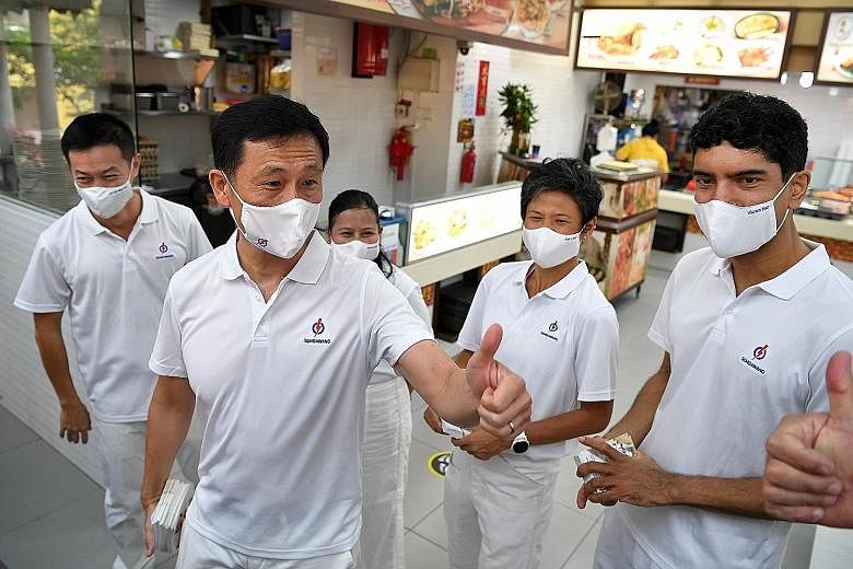 Education Minister Ong Ye Kung responding to a resident with a thumbs up during a walkabout at a coffee shop in Sembawang Drive last Wednesday. Mr Ong is helming the People's Action Party team contesting in Sembawang GRC, which also includes (from le