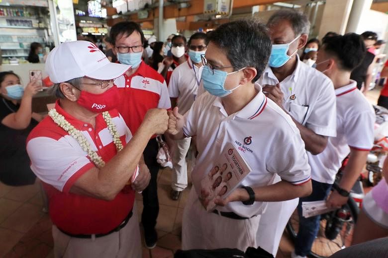 PSP chief Tan Cheng Bock (left) and Associate Professor Muhammad Faishal Ibrahim, who is in the PAP's Nee Soon GRC team, greeting each other at Chong Pang City Food Centre yesterday. Dr Tan says he and SDP chairman Paul Tambyah are prepared to go on 
