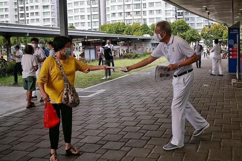 MARSILING-YEW TEE: PAP candidates Zaqy Mohamad (right), who is Minister of State for National Development and Manpower, and Alex Yam chatting with a resident at Woodlands interchange. MARSILING-YEW TEE: Singapore Democratic Party candidate Benjamin P