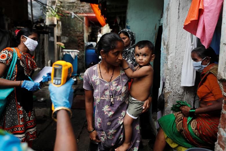 A healthcare worker checking the temperature of residents of a slum area during a check-up campaign for Covid-19 in Mumbai yesterday. India has failed to suppress new cases despite implementing one of the world's most expansive lockdowns at the end o