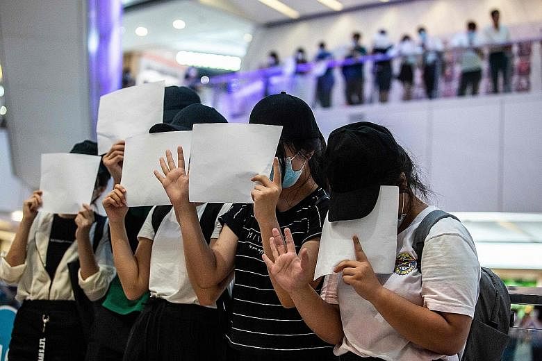 Riot police holding up a warning flag during a demonstration in a mall in Hong Kong on Monday that was held in response to Beijing's establishment of a national security law for the city that makes political slogans and signs advocating independence 